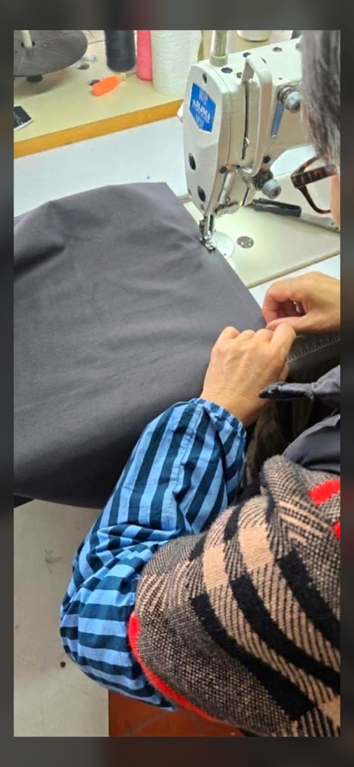 Close-up of a machinist sewing fabric on an industrial sewing machine